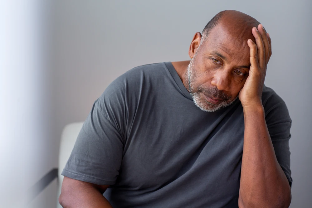 Tired man showing symptoms of low testosterone before enhancement.