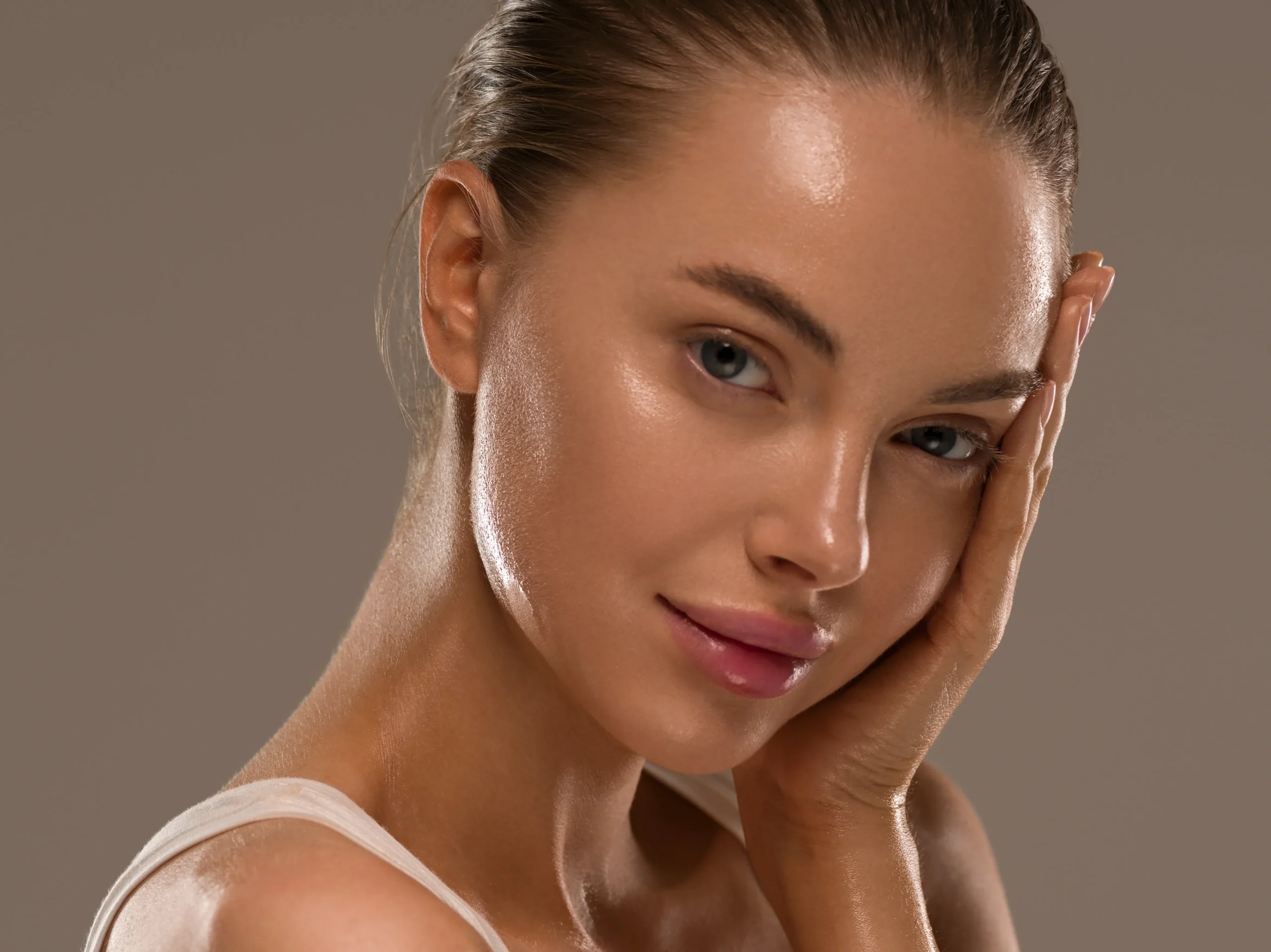 Person with smooth-looking skin resting a hand against their face