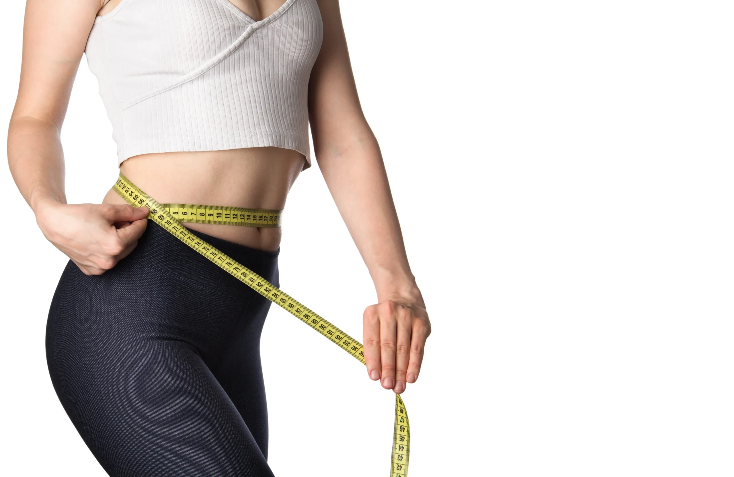 Person measuring their waist with a tape measure while wearing athletic clothing.